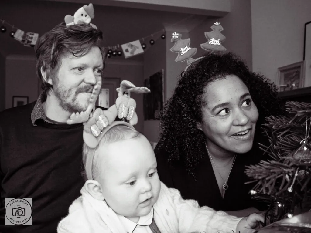 Mum, Dad and baby looking at Christmas tree