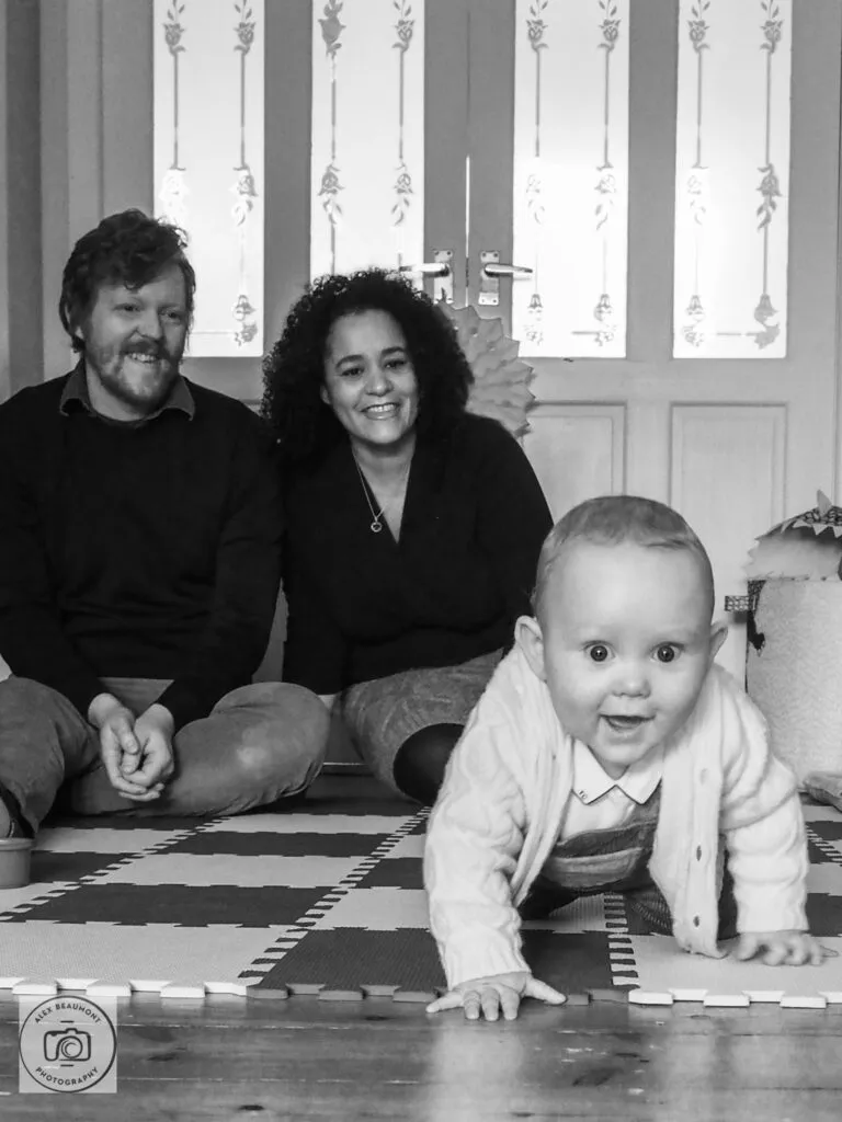 Baby crawling towards camera with mum & dad sat watching
