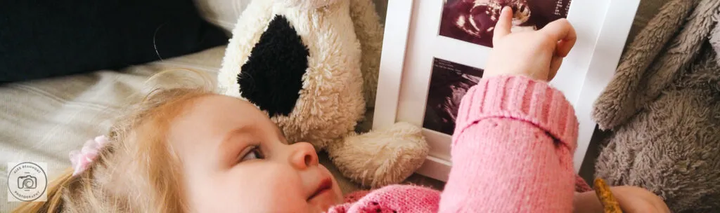 Toddler pointing at scan photo of sibling