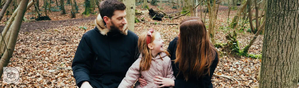 Mum and Dad sitting with child in woods