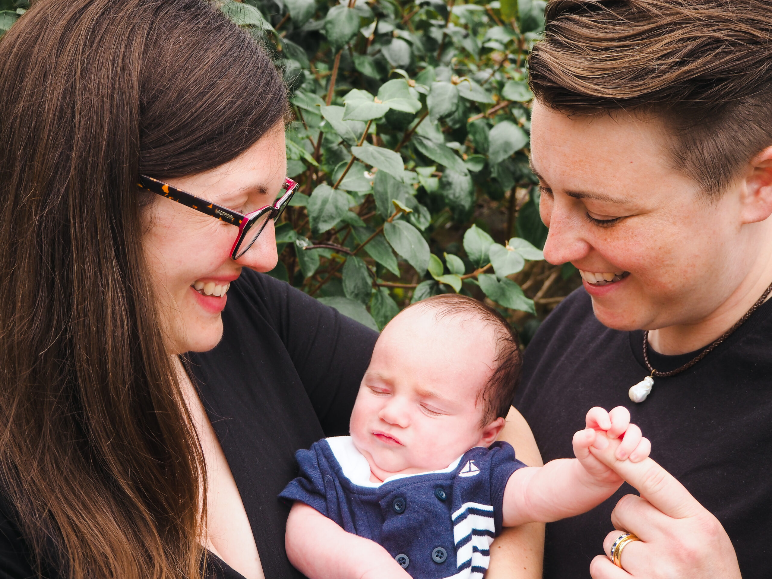 Mums smiling at newborn standing in garden